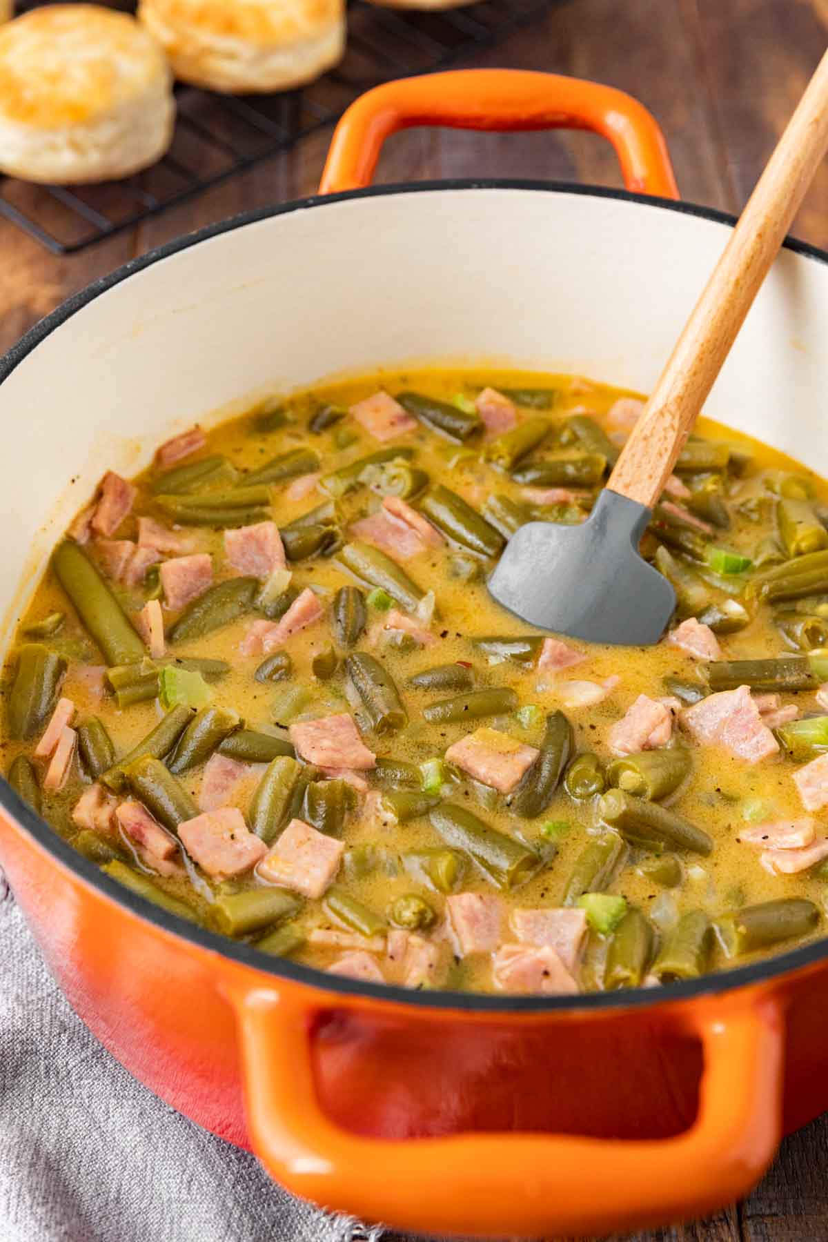 Popeye's Green Beans in dutch oven with rubber spatula stirring