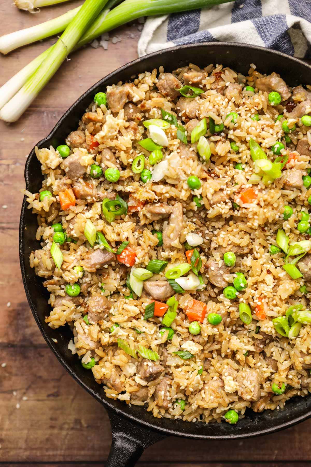 Pork Fried Rice in skillet with vegetables, egg, and sesame seed garnish