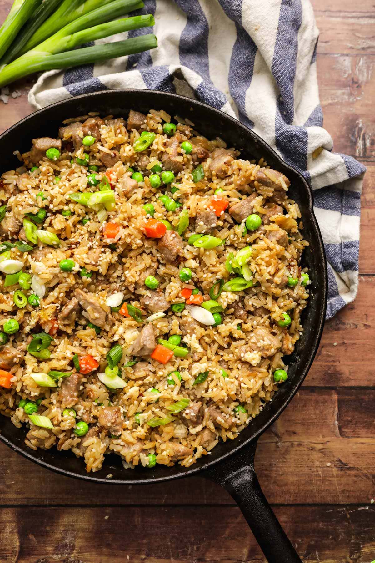 Pork Fried Rice in skillet with vegetables, egg, and sesame seed garnish