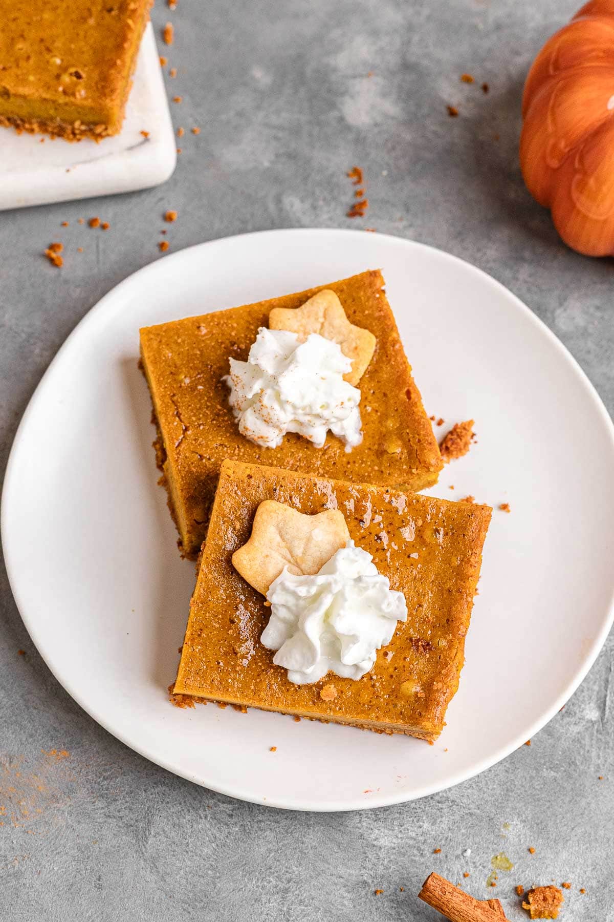 Sliced Pumpkin Pie Bars with whipped cream served on a plate.