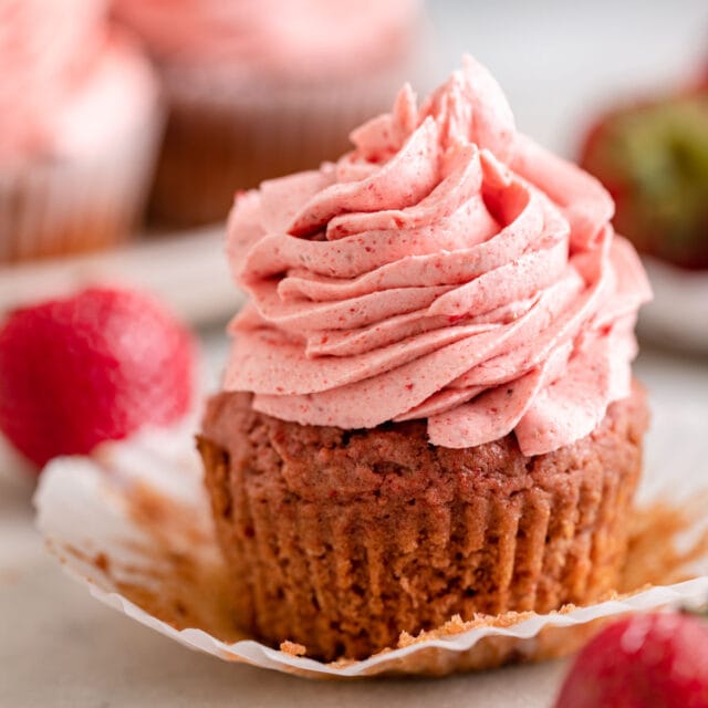 Strawberry Cupcakes frosted with strawberry on top with wrapper peeled back