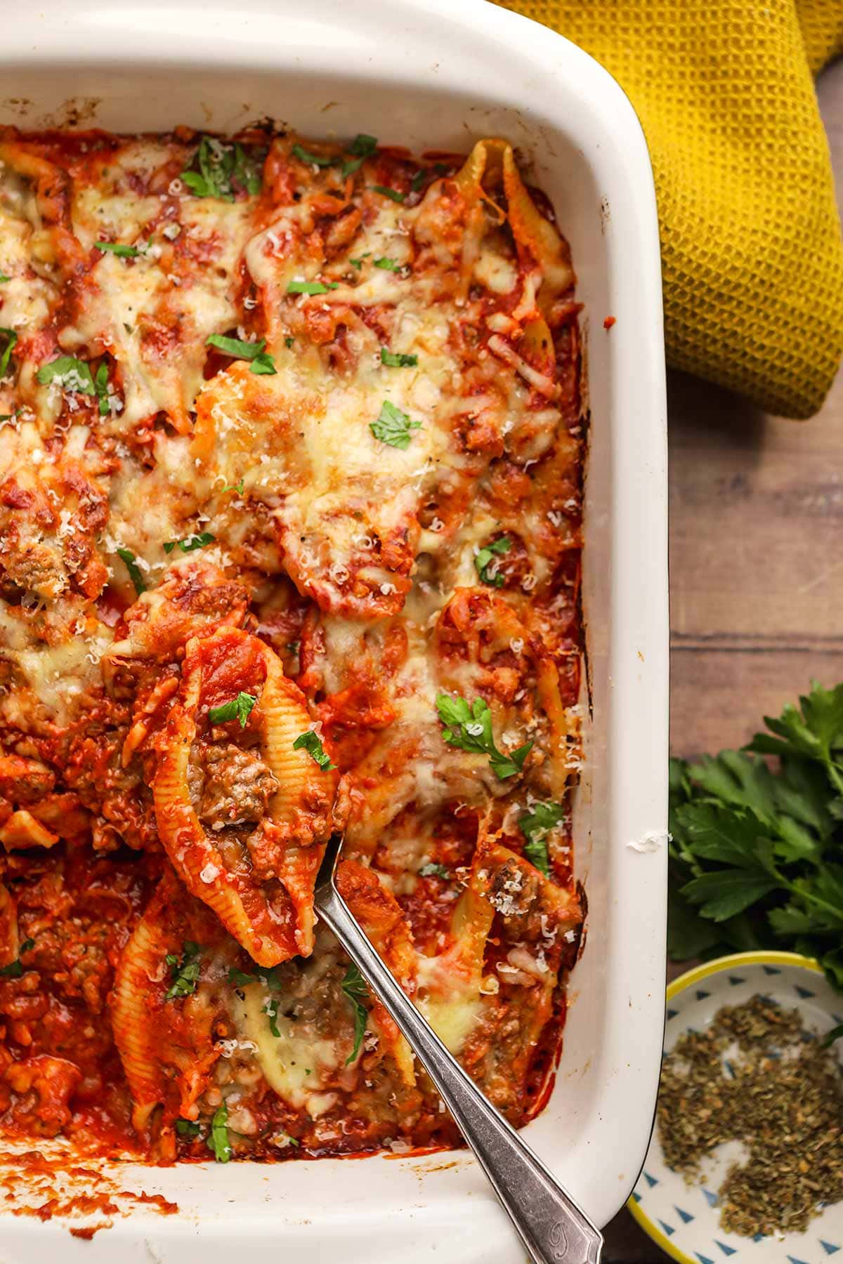 Beefy Italian Stuffed Shells spoon scooping shell from baking dish