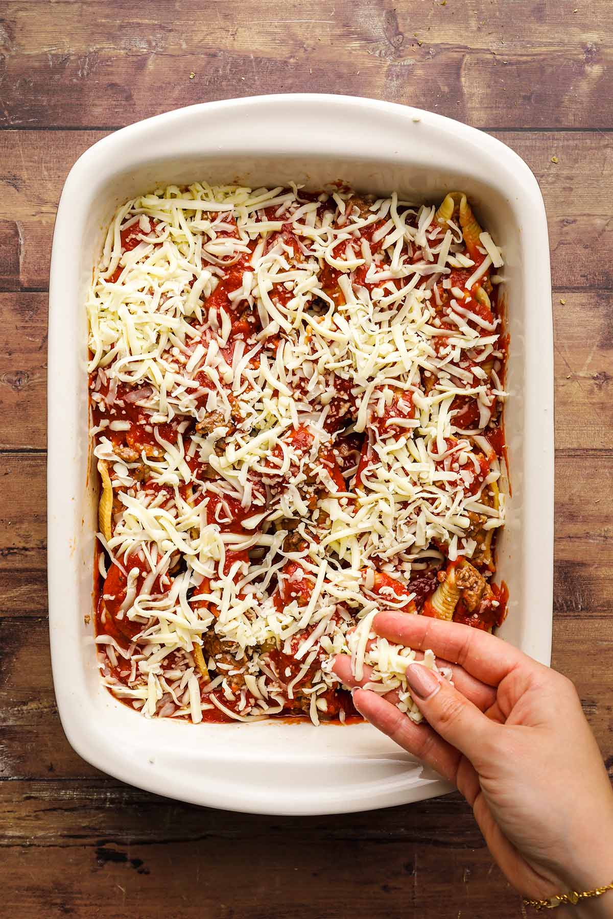Beefy Italian Stuffed Shells beef mixture inside shells in baking dish with sauce and cheese