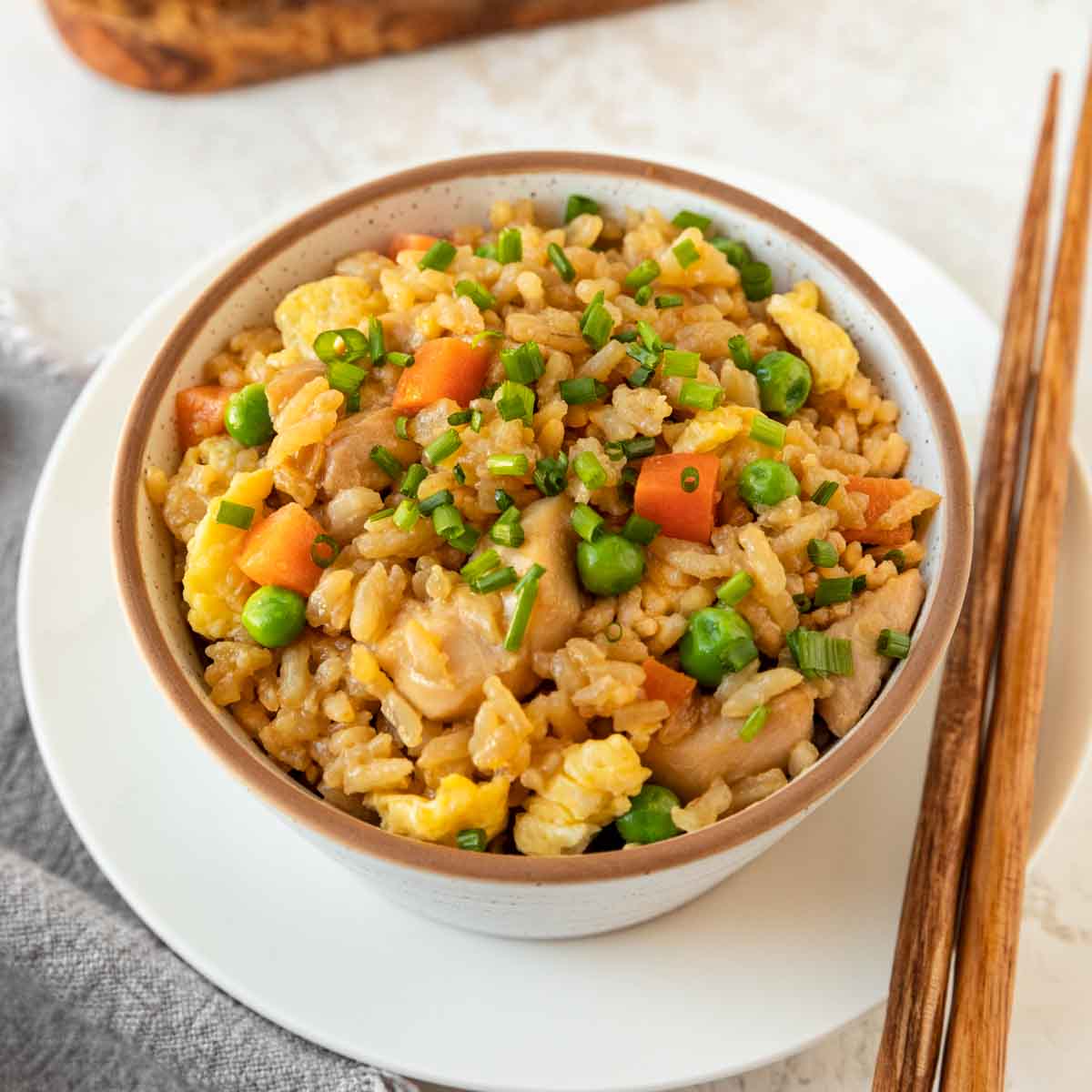 Chicken Fried Rice in bowl with chopsticks on plate