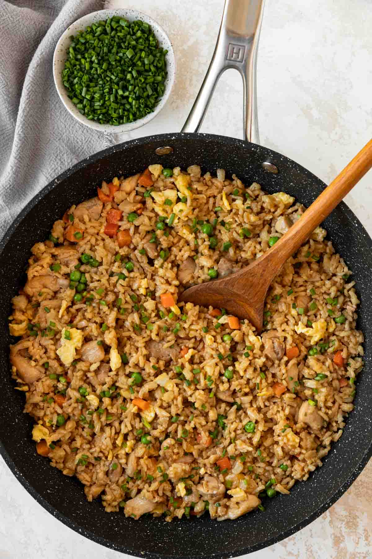 Chicken Fried Rice finished dish in a skillet with wooden spoon