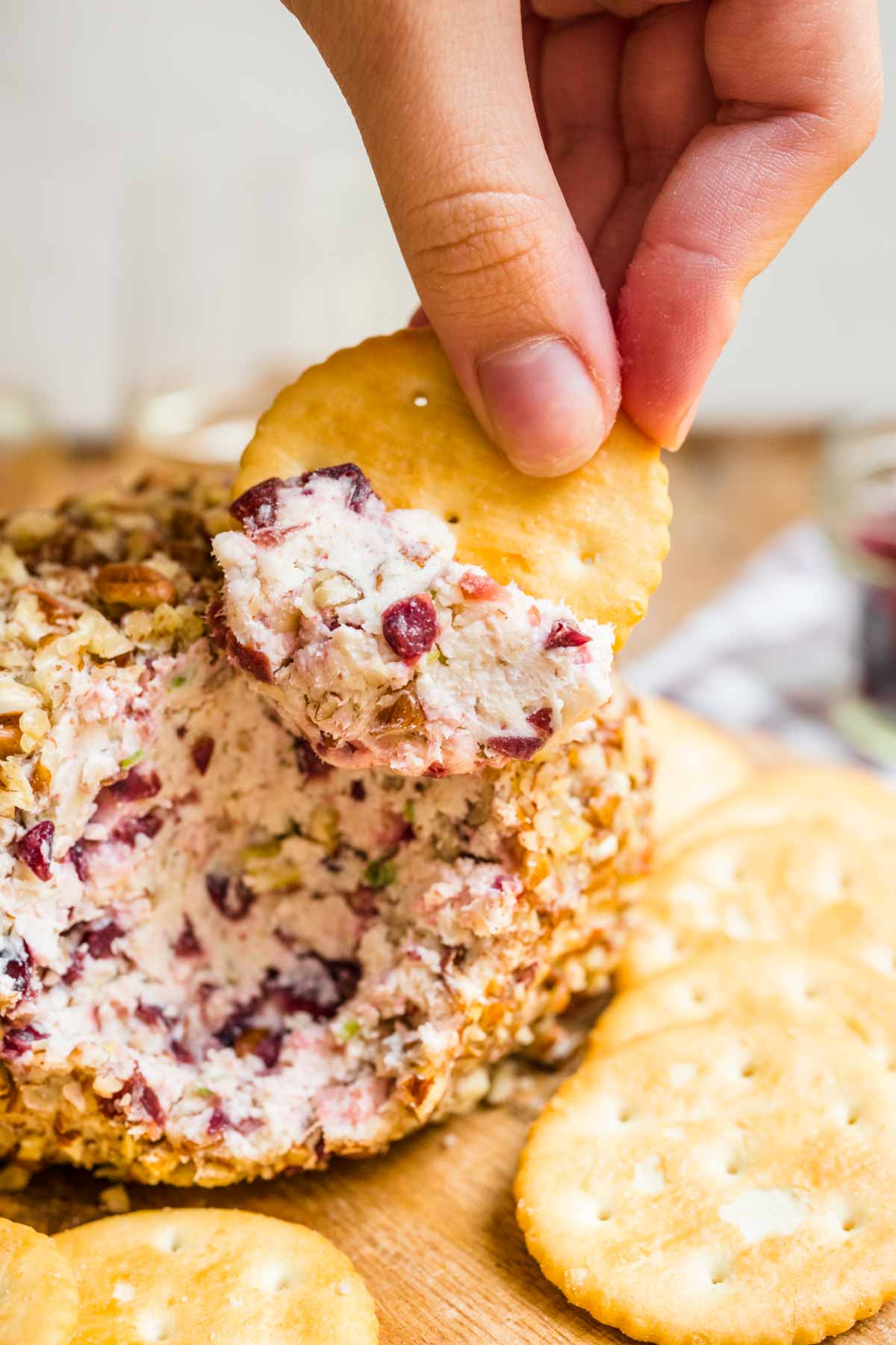 Cranberry Pecan Cheese Ball on serving tray with crackers and cut open