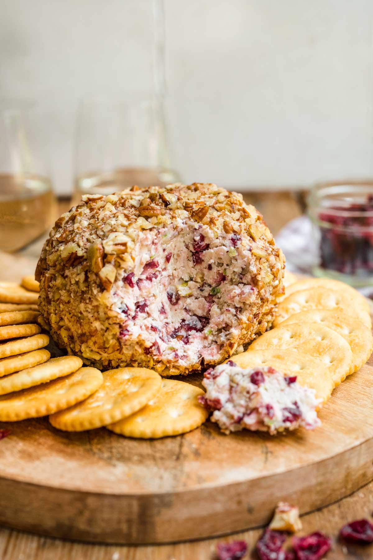 Cranberry Pecan Cheese Ball on serving tray with crackers and cut open