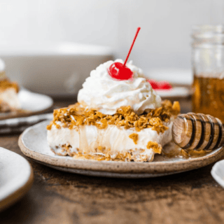 ice cream served with honey topping whip cream and cherry
