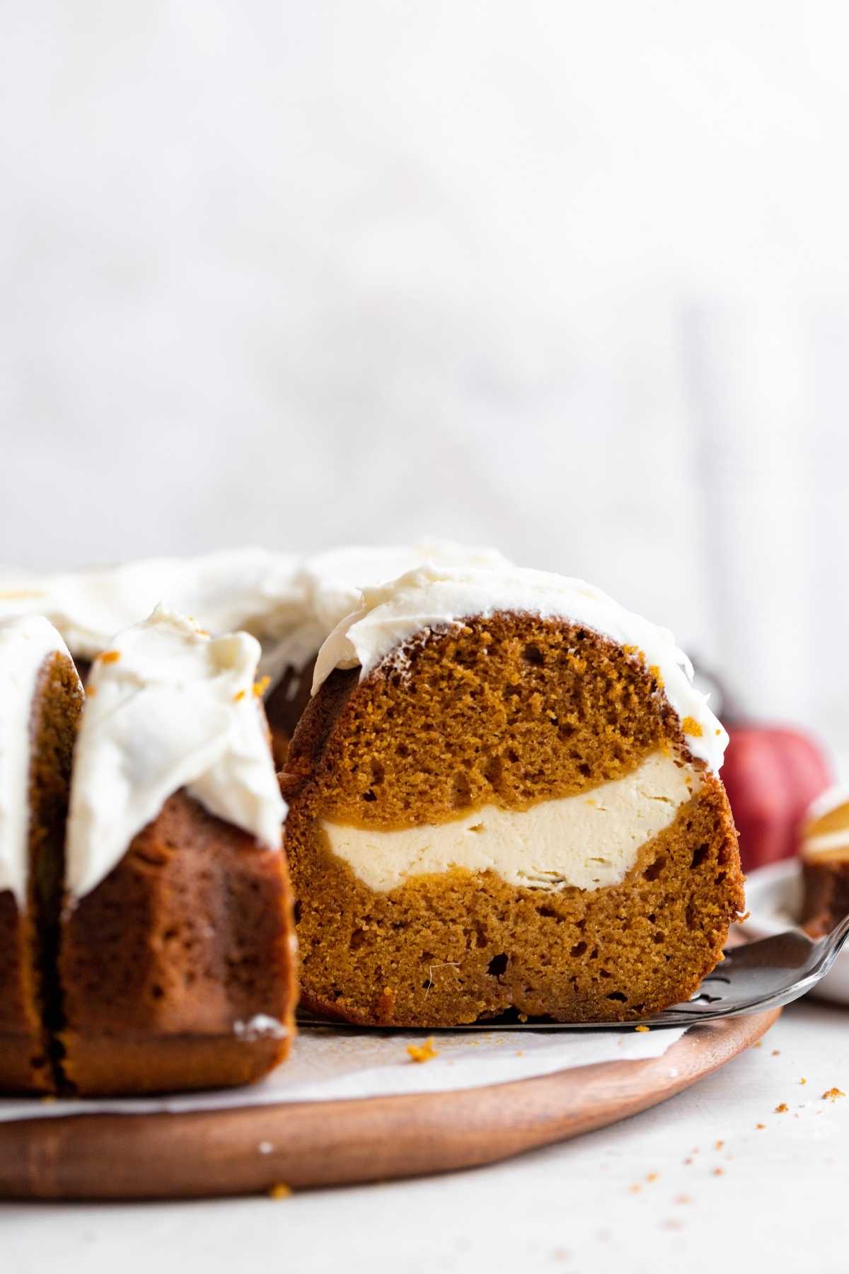 Pumpkin Cheesecake Bundt Cake on cake plate with slice removed