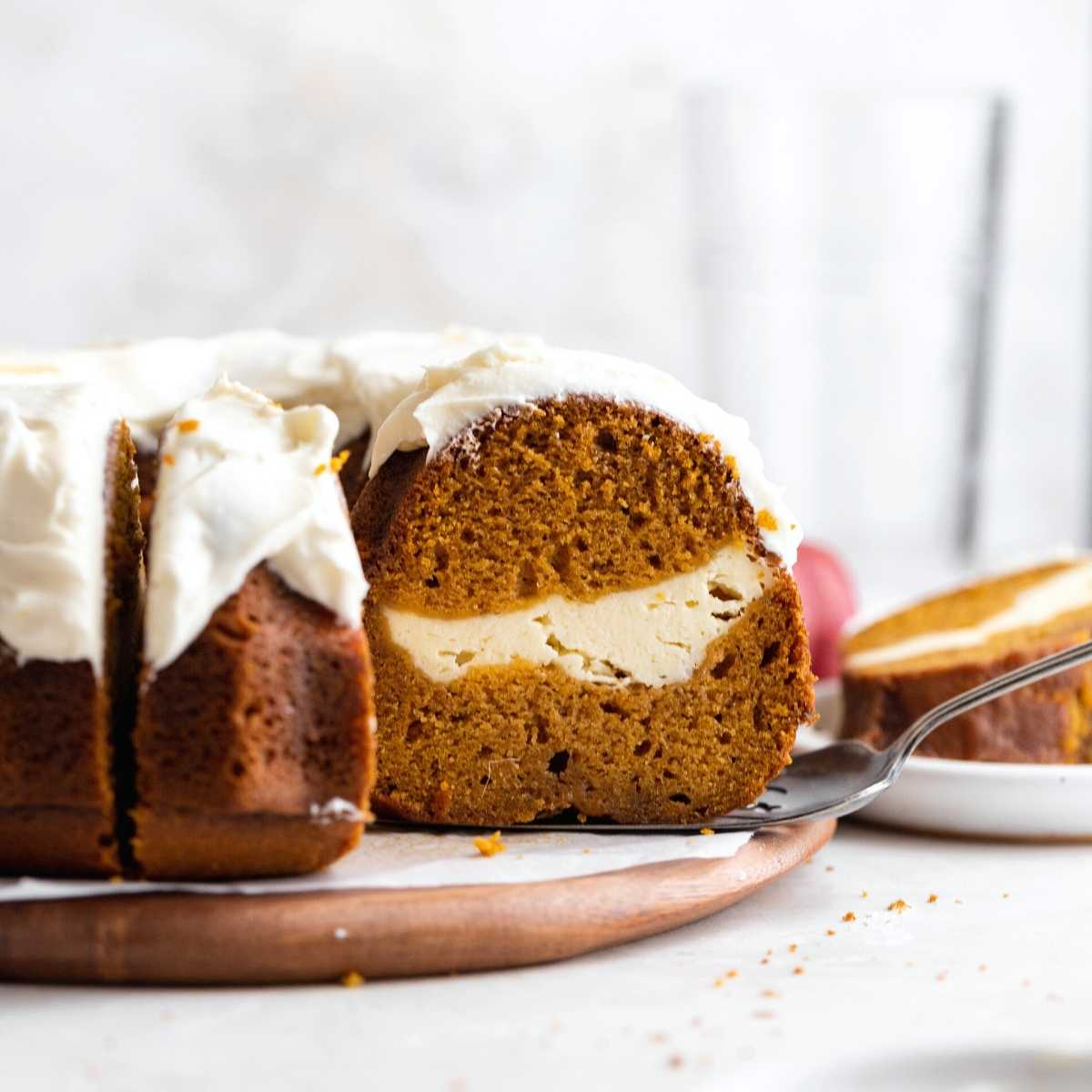 Pumpkin Cheesecake Bundt Cake on cake plate with slice removed