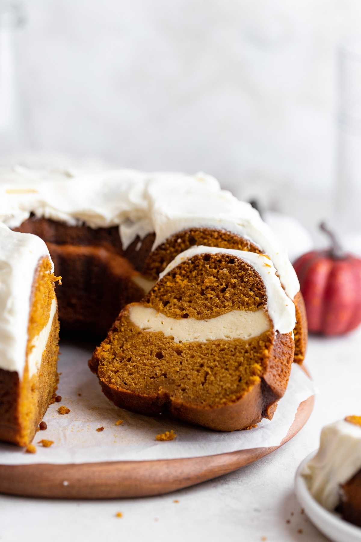 Pumpkin Cheesecake Bundt Cake on cake plate with slice removed