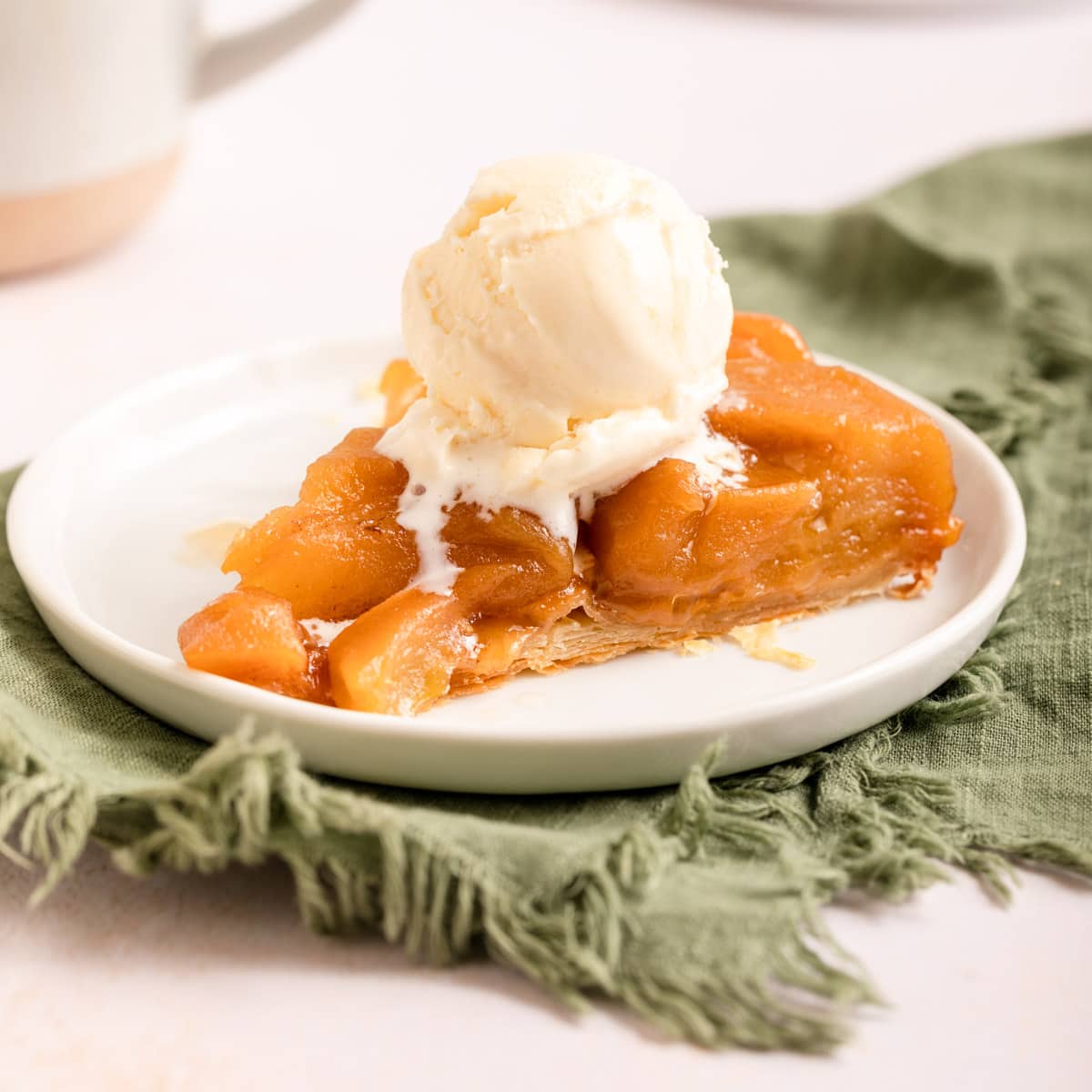 Tarte Tatin baked slice on plate with scoop of vanilla ice cream