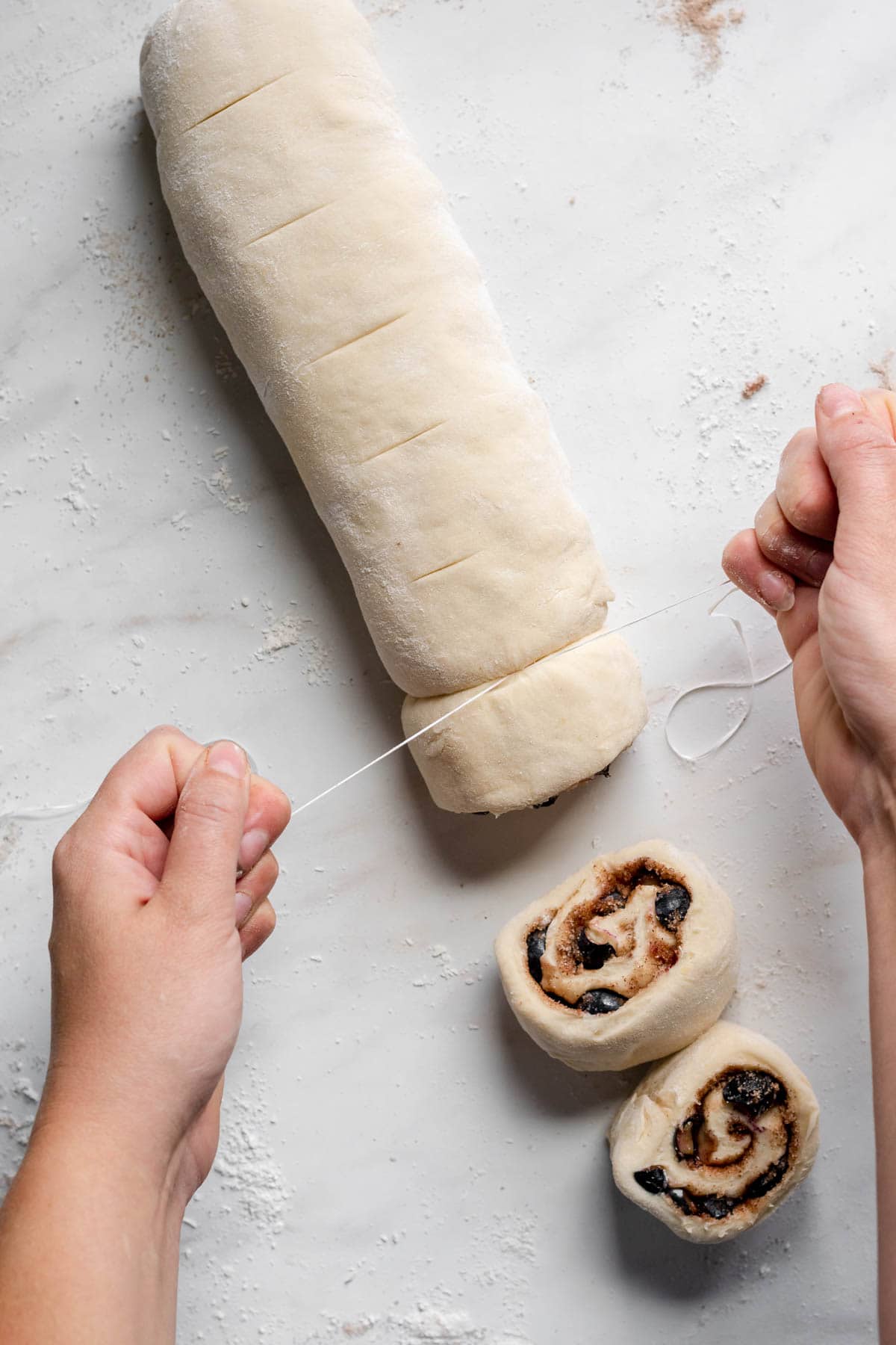 Blueberry Lemon Cinnamon Rolls cutting rolled dough with string