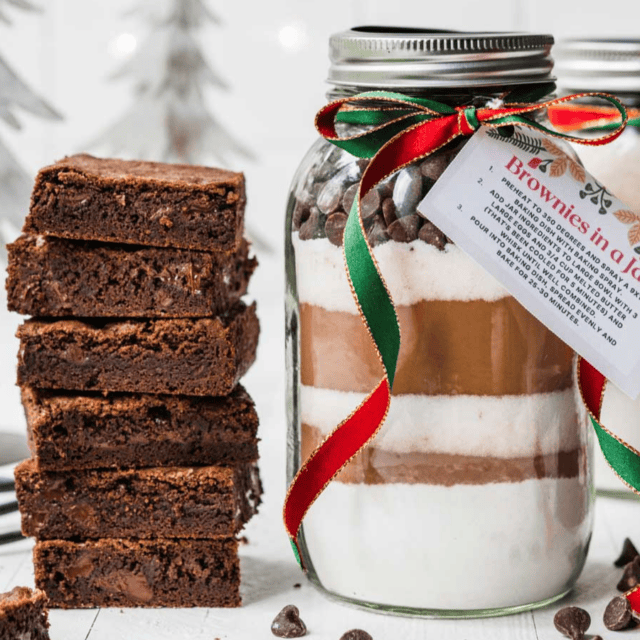 stack of brownies next to mason jar with dry ingredients