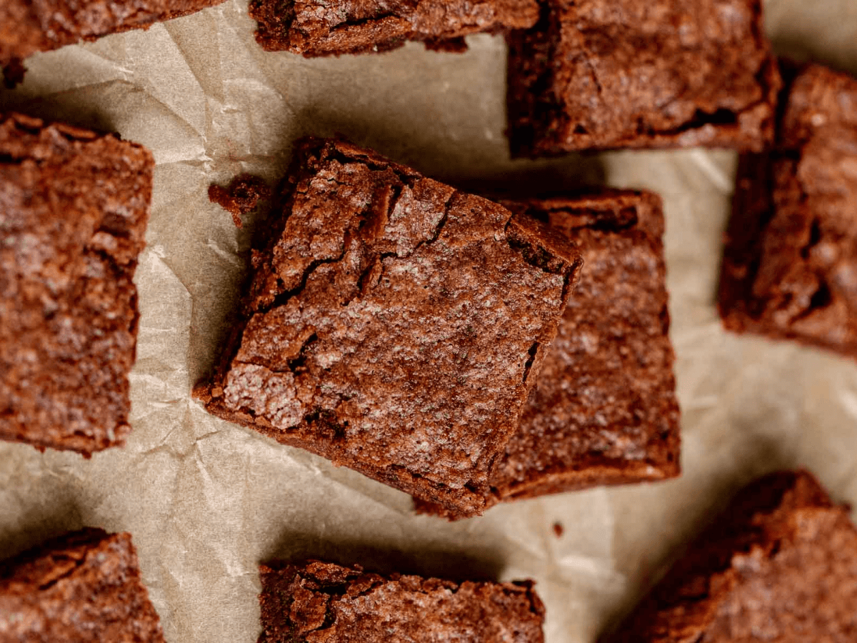 aerial view of chewy chocolate dessert squares on a baking sheet stacked on one another