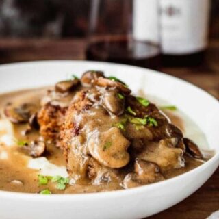 Steak and gravy served over mashed potatoes and shown from the side