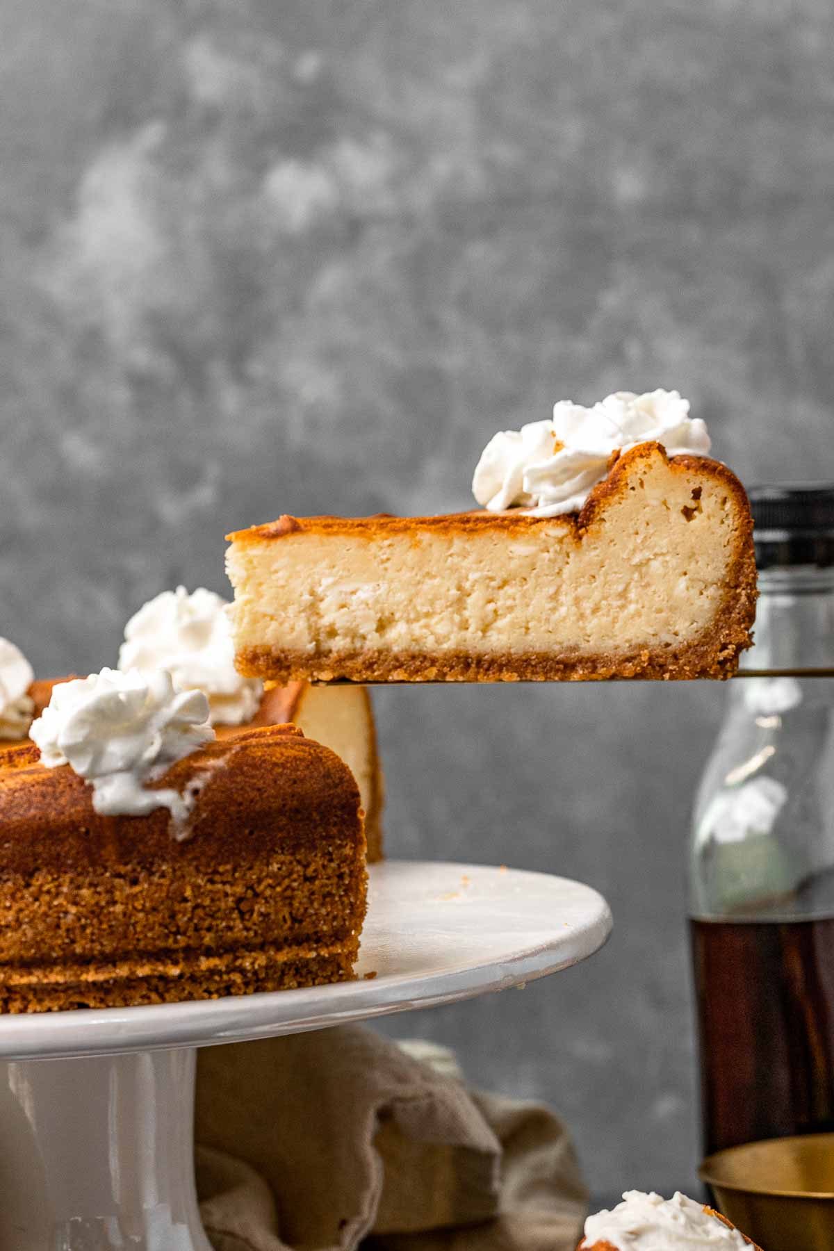 Maple Cheesecake slice being removed from cheesecake on serving platter