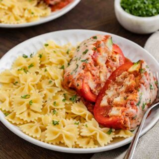 Chicken Parmesan Stuffed Peppers on a plate with bowtie pasta and fork, 1x1 ratio