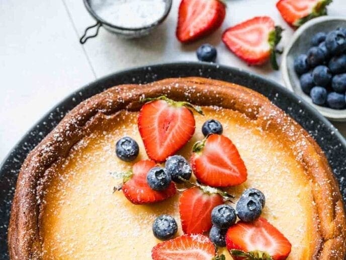 Partial cheesecake shown with berries on top