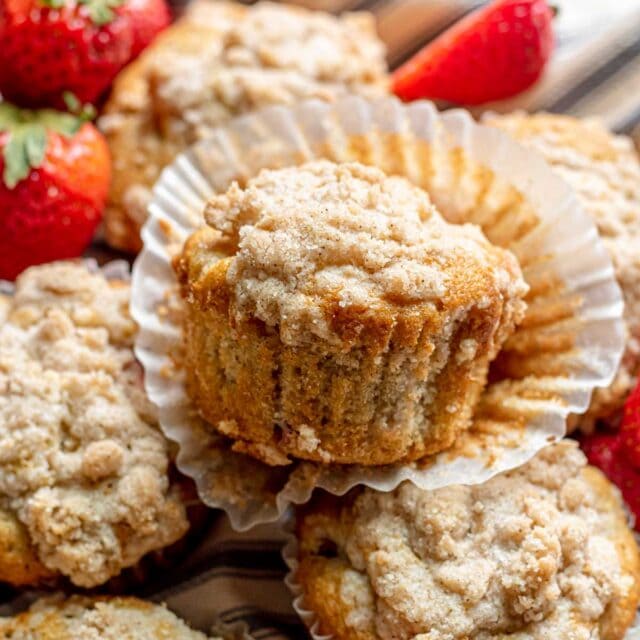 Strawberry Crumb Muffins baked in basket with wrapper pulled down on top muffin