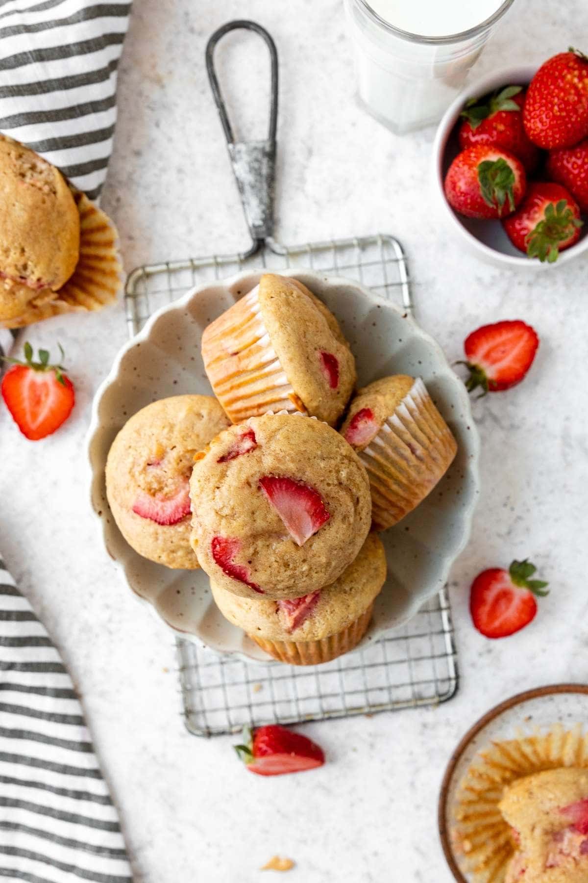 Strawberry Muffins in serving dish on cooling rack with fresh strawberry garnish