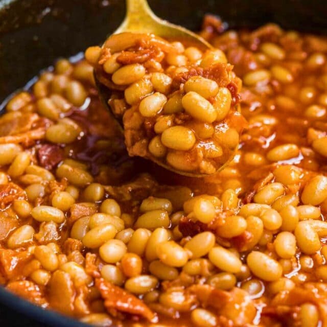 spoon scooping beans over a pot