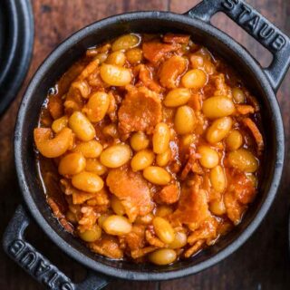 cooked pork and beans in small black pot