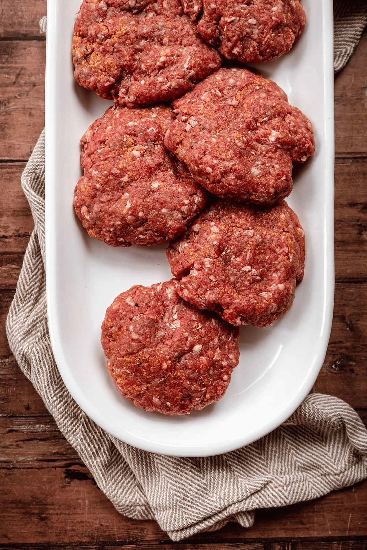 Beef patties on a white platter