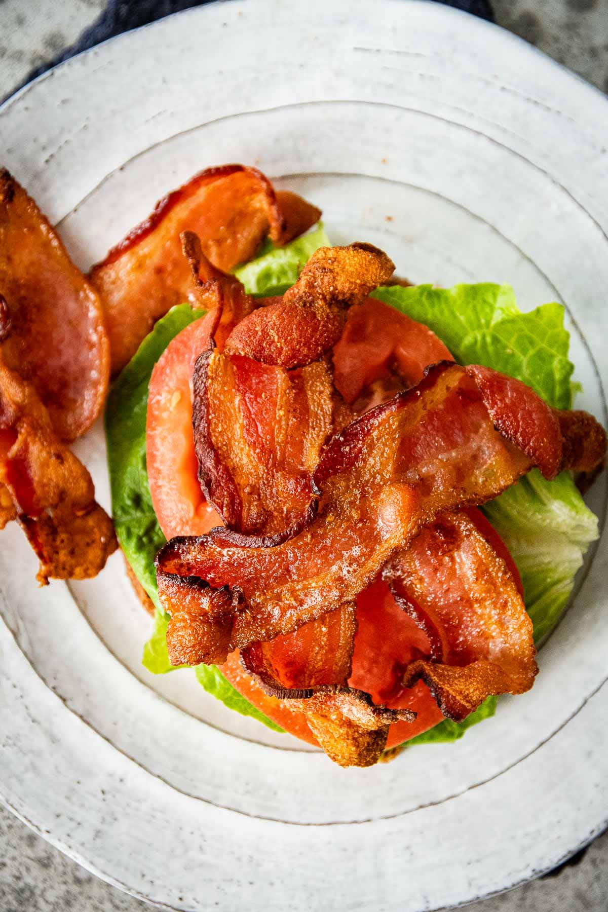 Air Fryer Bacon on serving plate over lettuce