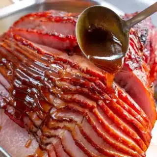 glaze being spooned over ham