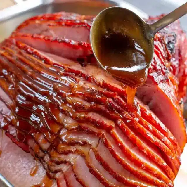 glaze being spooned over ham