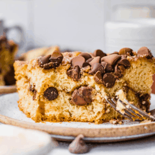 Slice of baked cake with chocolate chips and fork.