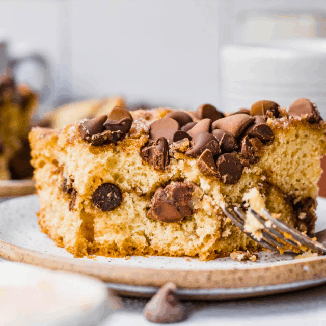 Slice of baked cake with chocolate chips and fork.