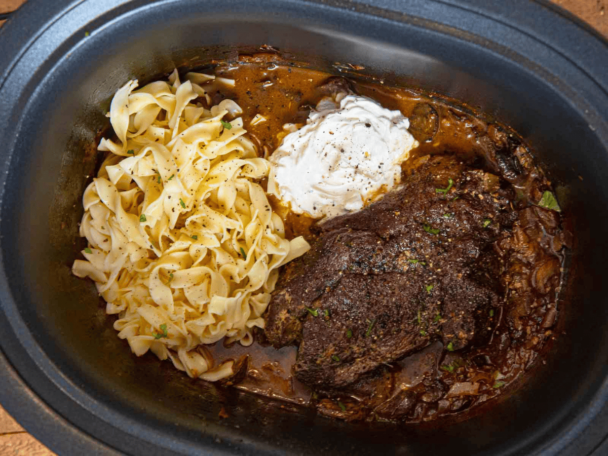 noodles, beef, sour cream, and sauce in a pot