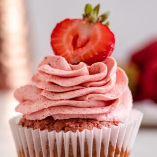 strawberry frosting on cupcake with sliced strawberry on top