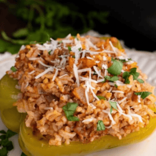Green bell pepper stuffed with rice filling on a white plate