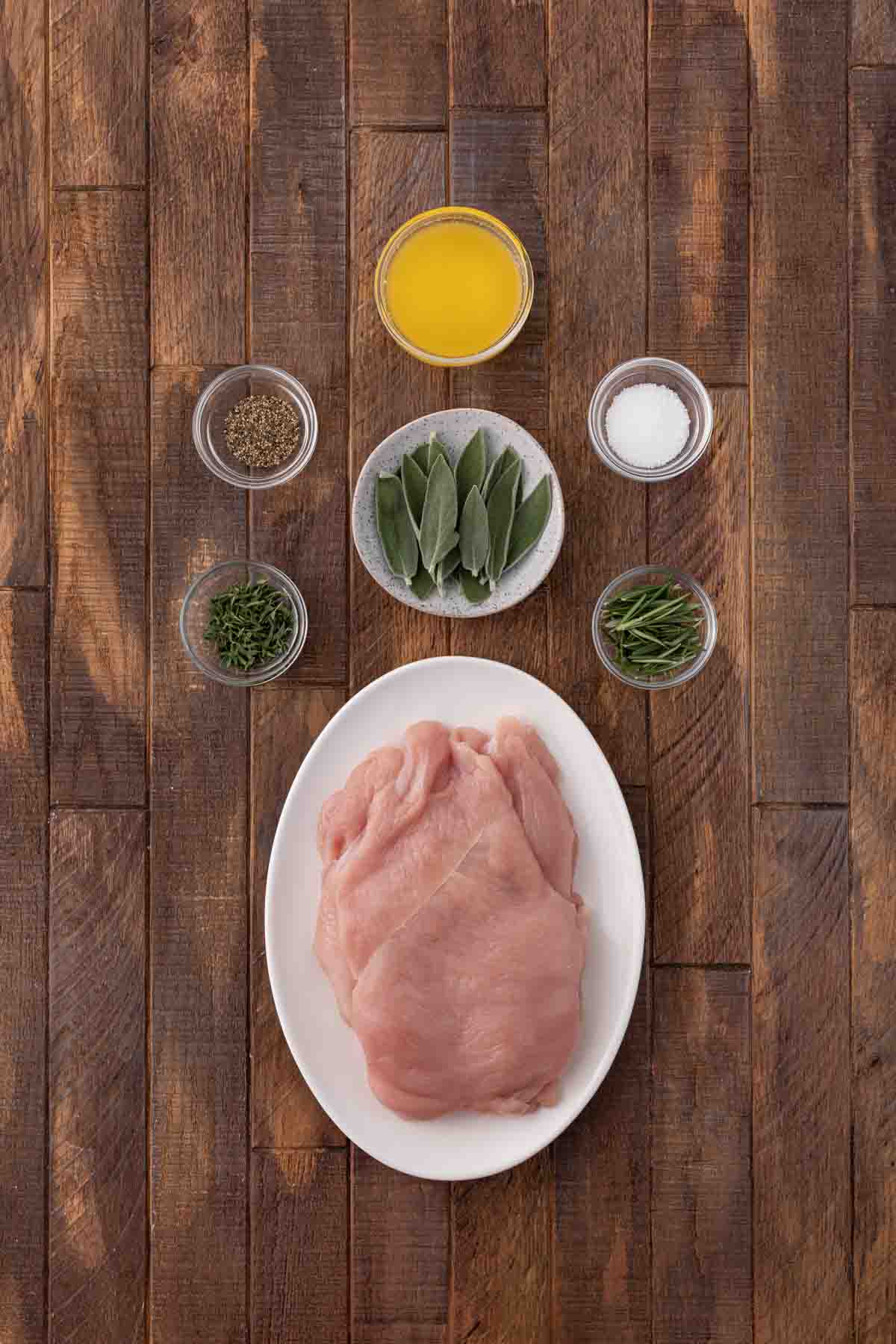 Air Fryer Herb Butter Turkey Breast ingredients in separate prep bowls and raw breast on oval plate.