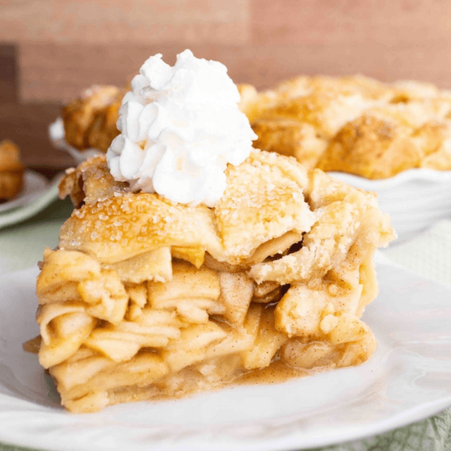 slice of pie on a plate topped with whipped cream