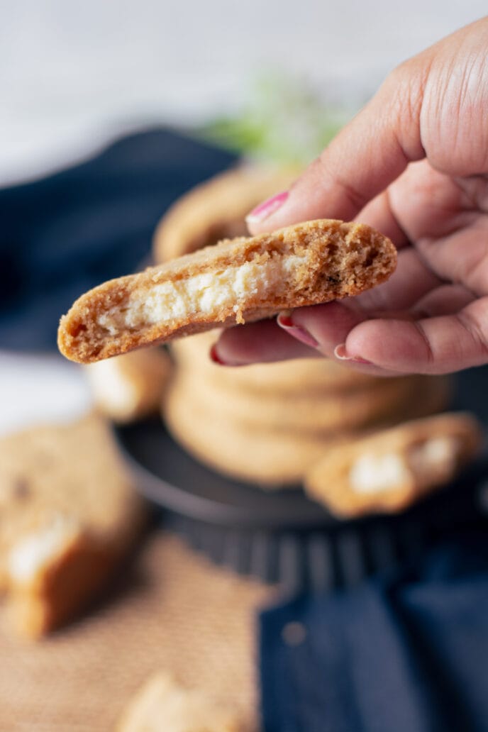 Cheesecake Stuffed Chocolate Chip Cookies baked in hand cut in half to see filling