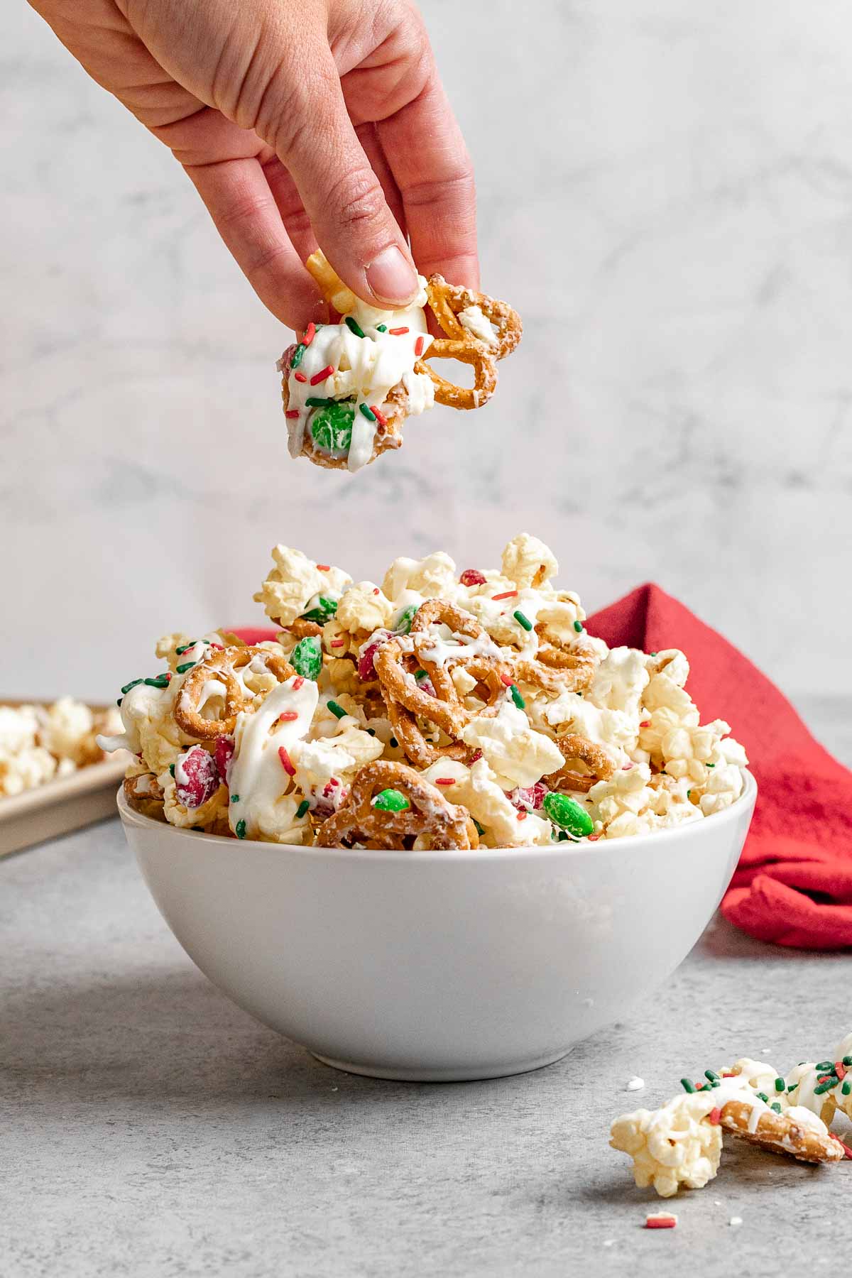 Christmas Popcorn Crunch in Bowl with hand holding portion