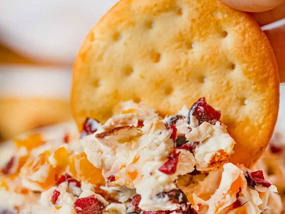dipping crackers into cheese spread
