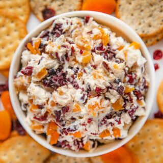 Bowl of finished cheese spread on plate of crackers