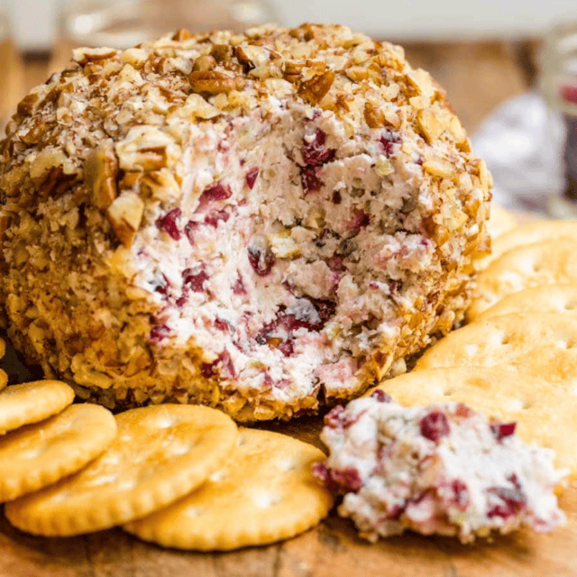 cheeseball on a wooden plate with crackers