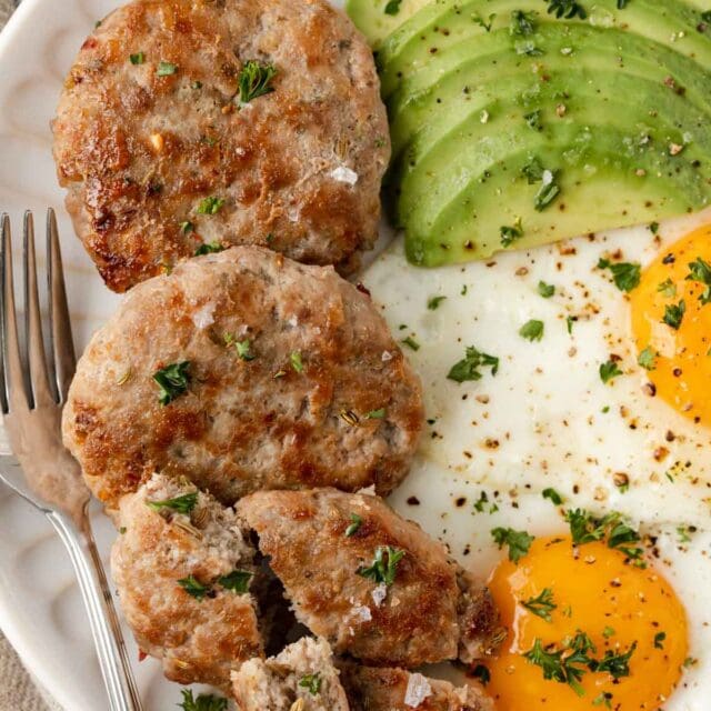 plate of Maple Breakfast sausage with 2 fried eggs and slices of avocado closeup