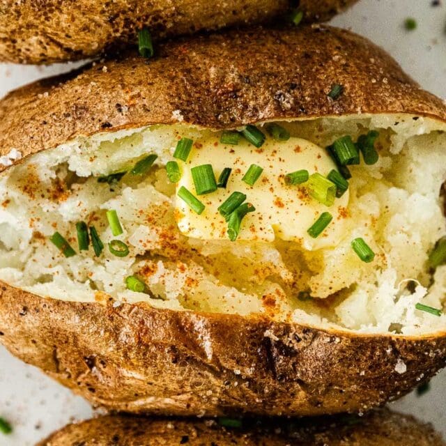 Baked potato with butter and green onions.