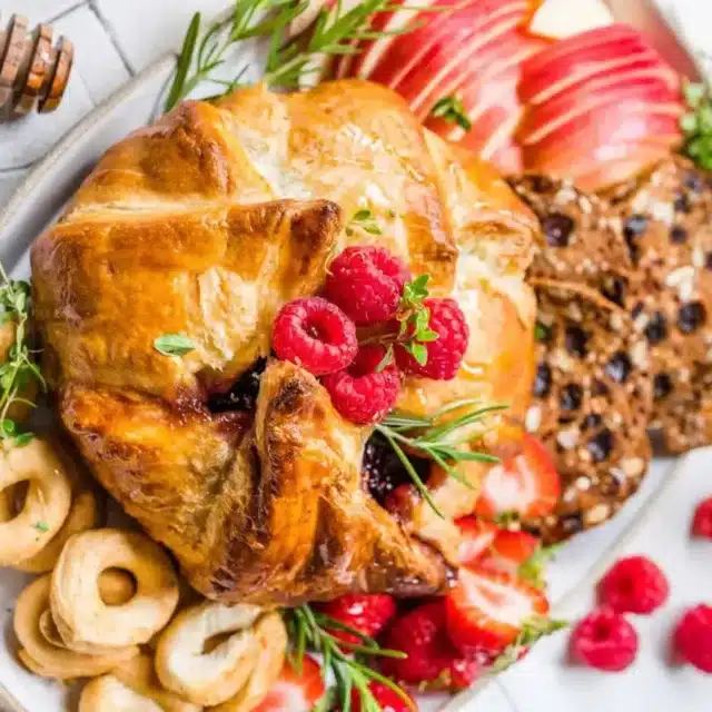 Top view of pastry covered brie with apples and crackers