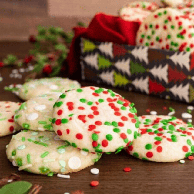 Cookies with sprinkles laid out in front of gift box