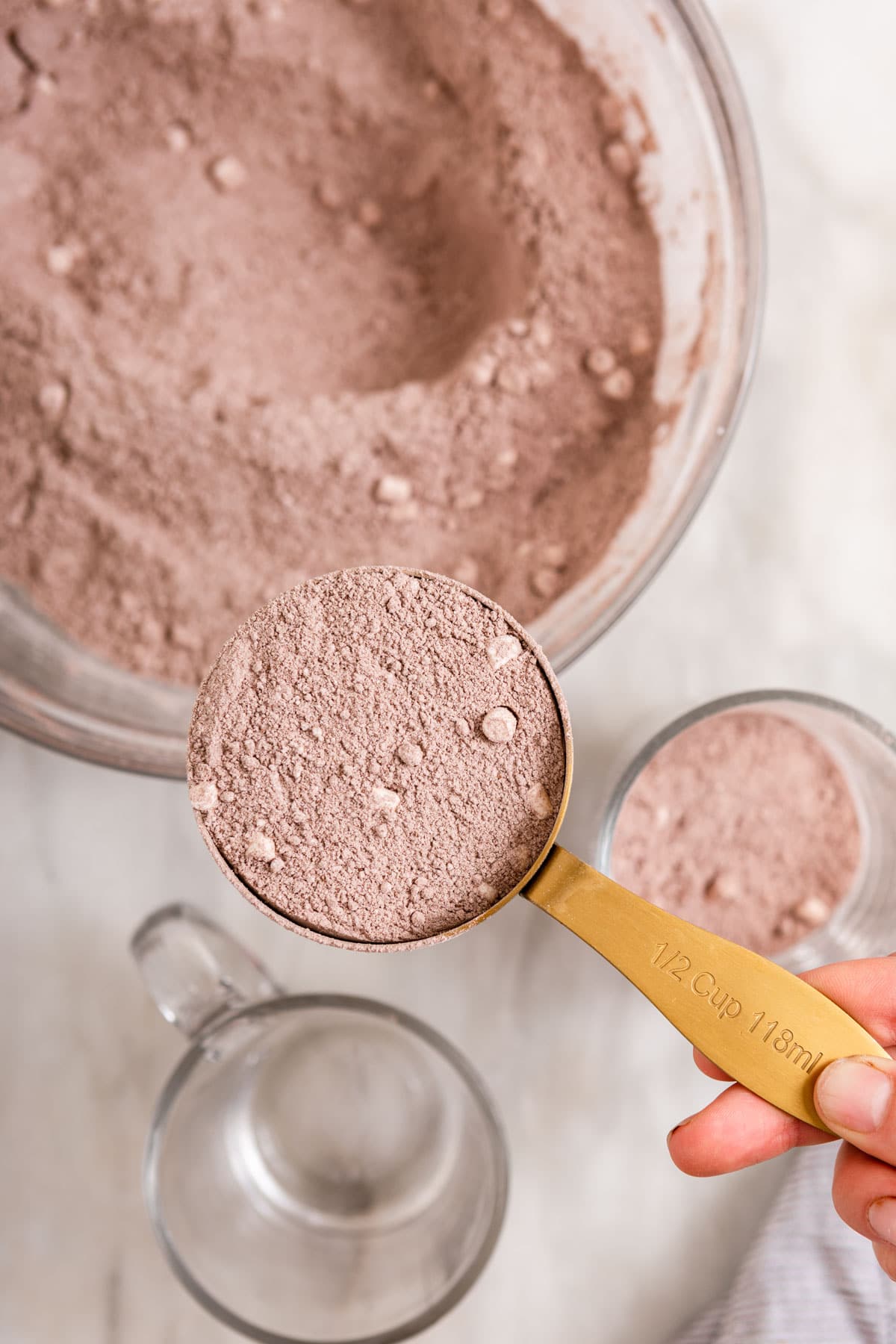 Hot Chocolate Mix ingredients in large glass bowl with measuring cup