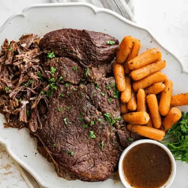Beef roast on a plate with carrots