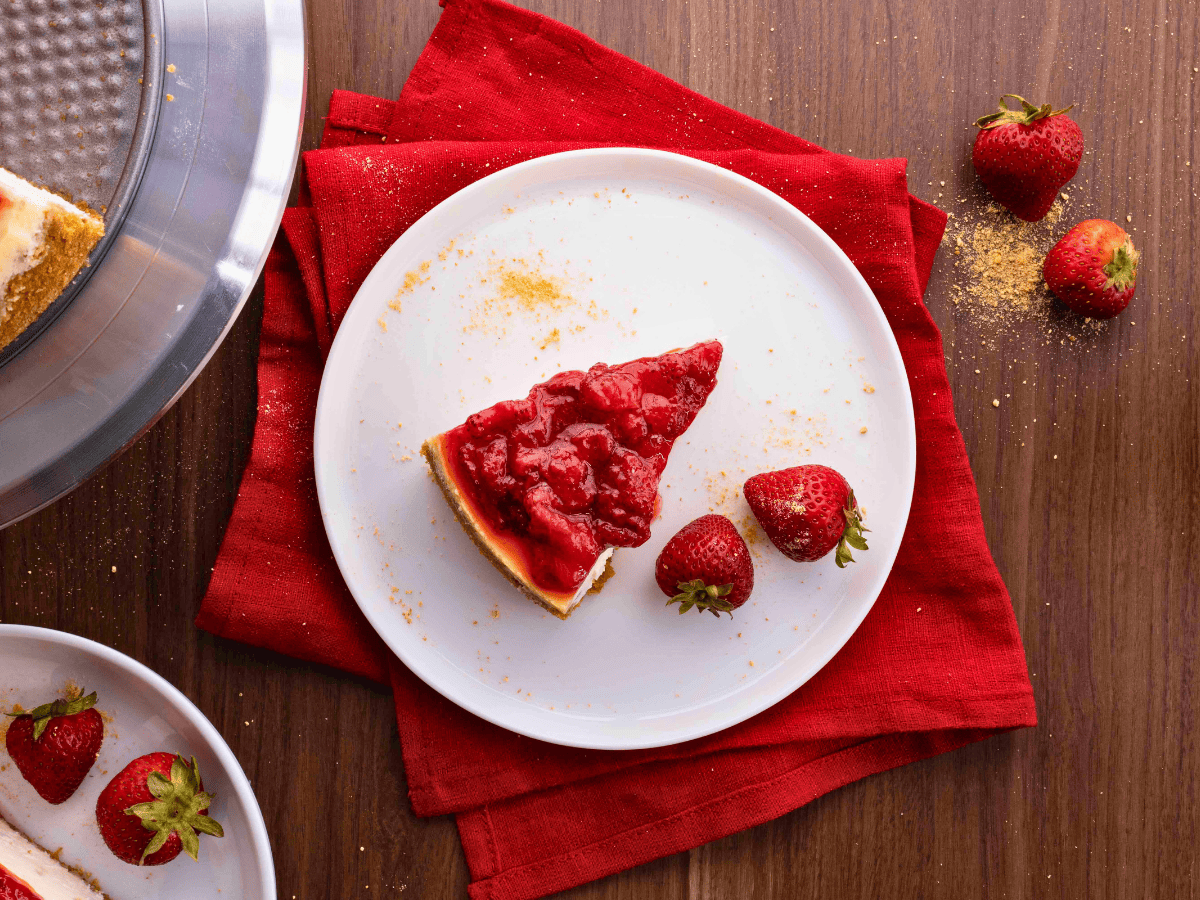 top view of slice of cream cheese dessert with strawberries on a white plate